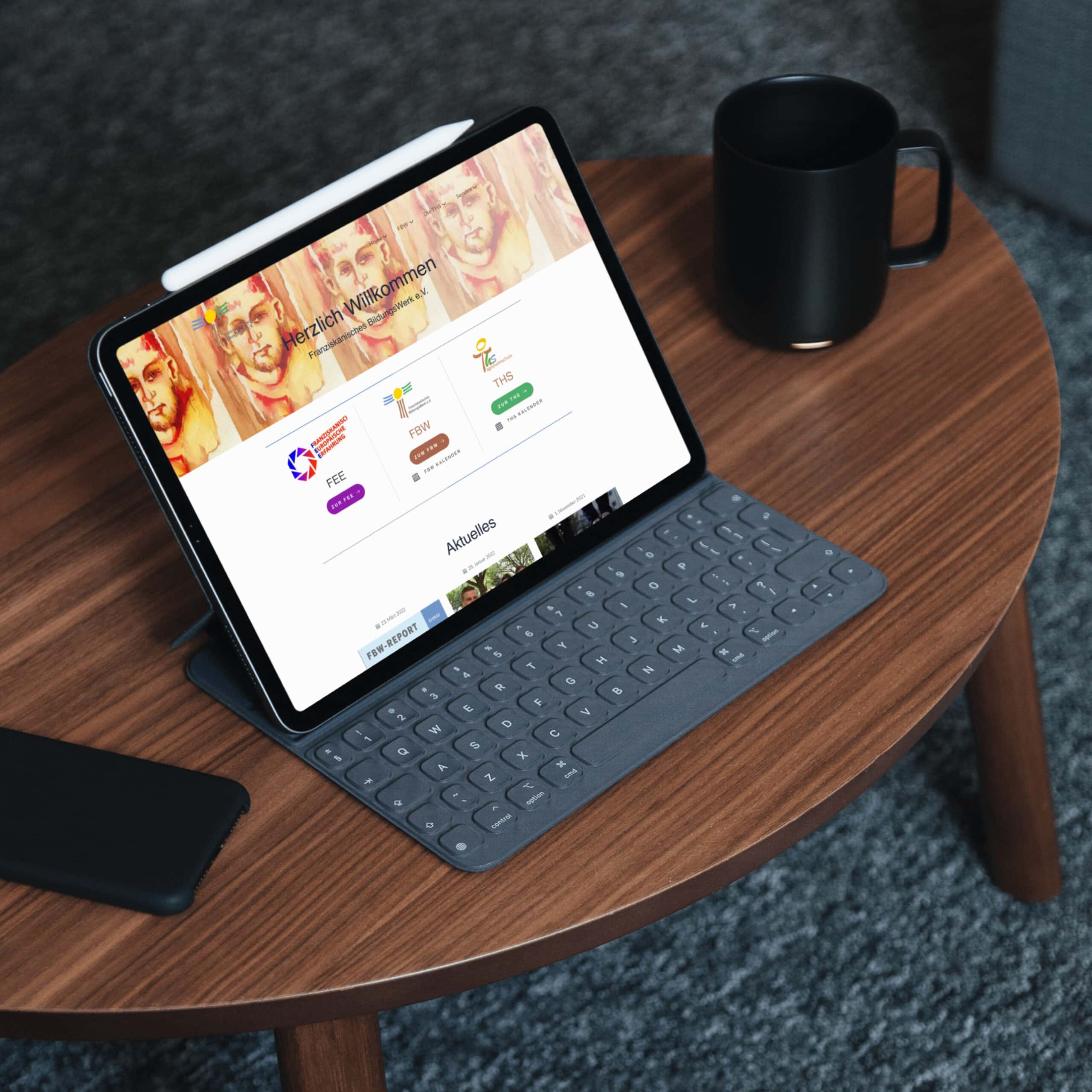 Auf einem Tisch liegt ein iPad neben einer Kaffeetasse.