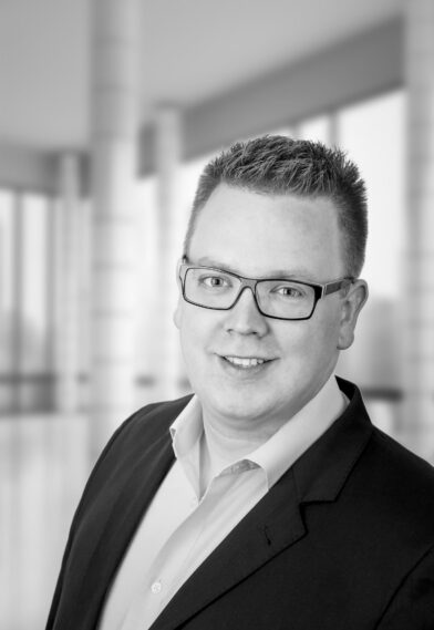 Ein Schwarz-Weiß-Foto eines Mannes mit Brille.
